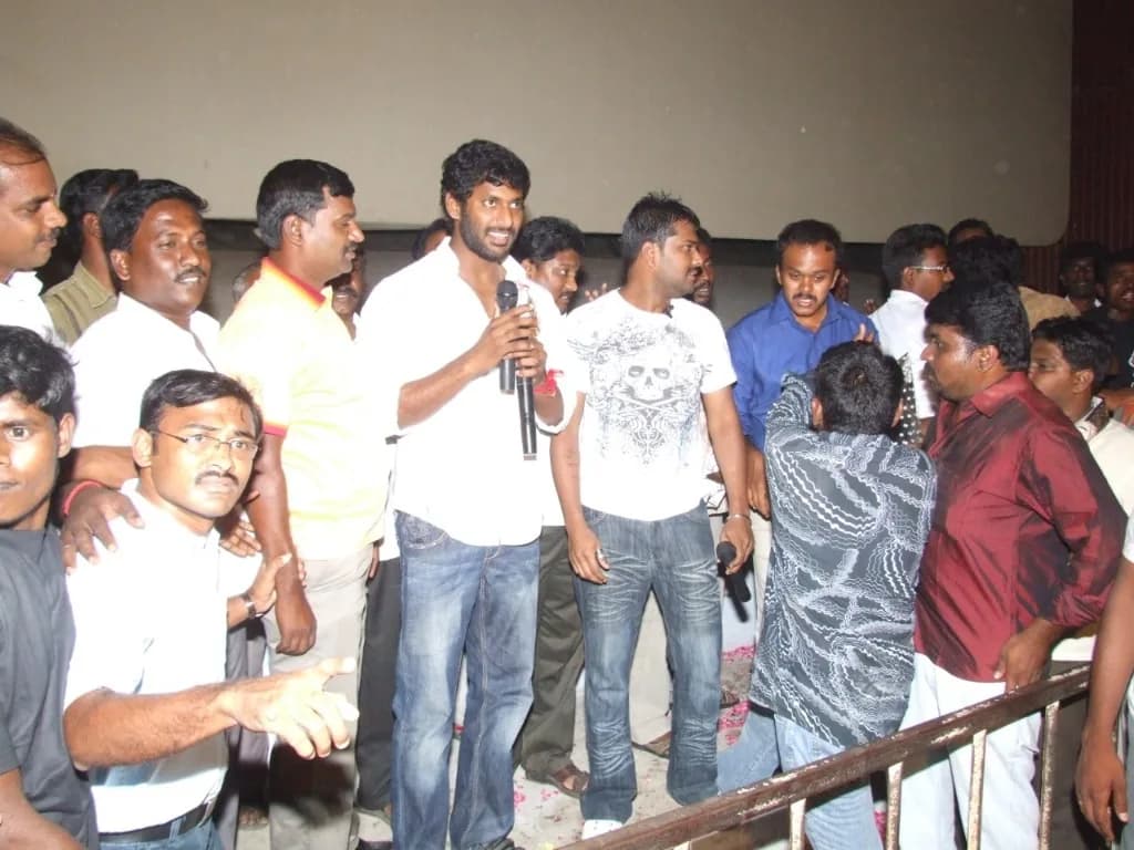 Actor Vishal speaking at an event with AirMedia team members nearby