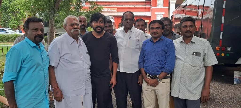AirMedia team with celebrity guests outdoors near a campus building